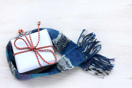 flat layout of a gift with a striped bow, wrapped in a blue scarf top view of the surface light / warm surprise for the holidayの写真素材