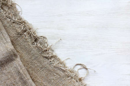 flat layout with crumpled linen cloth on a light wood surface top view / fabrics on the tableの写真素材