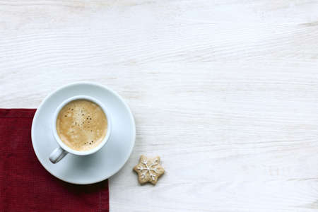 frothy espresso in a small cup and ginger snowflake top view / winter coffee breakの写真素材