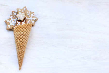 edible wafer cone with ginger cookies on a light wooden surface top view / delicious festive dessertの写真素材