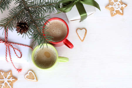 frothy coffee in a red and green mug, surrounded by ginger cookies and Christmas tree top view / festive coffee break in the new year eveの写真素材