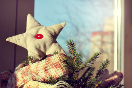 real green Christmas tree decorated soft star against the window with the urban landscape / winter holidays with holiday spiritの写真素材