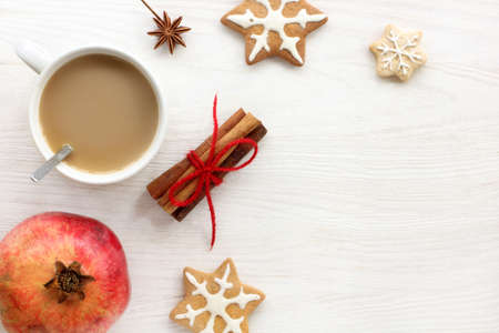 white cup with a drink surrounded by cinnamon, pomegranate and ginger cookies top view / breakfast desserts for the holidayの写真素材