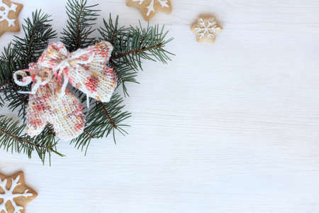 soft and warm mittens, knitted by hand on the background of fir branches and ginger cookies / cozy winter holidaysの写真素材
