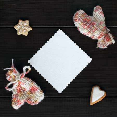 clean patterned sheet surrounded by knitted mittens and figured cookies, top view / for the heart and warm greetingsの写真素材