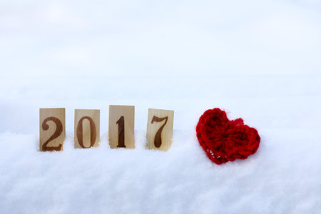 soft manually knitted heart symbol, and wooden numbers on a background of a winter landscape / day enamored 2017の写真素材