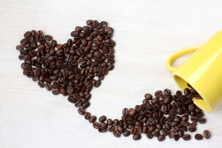 roasted grains black coffee, poured at desk of the yellow circles, forming a heart shape / flavor of true loveの写真素材
