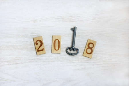 lay flat wooden figures and a top view of an iron key / important year number 2018の写真素材