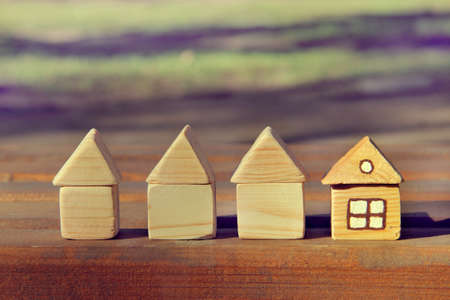 concept of four wooden houses one of whom ready for living / different from otherの写真素材