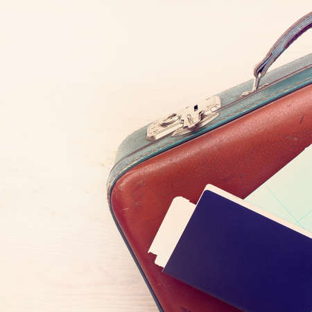 blue passport with map lays on a retro suitcase view from above / fees of things for travelの写真素材