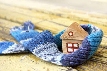 small wooden house in a warm blue scarf/ COZY dwelling at any seasonsの写真素材