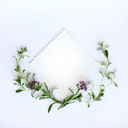 flat lay background with flowers and leaves as a wreath and blank patterned sheet for...