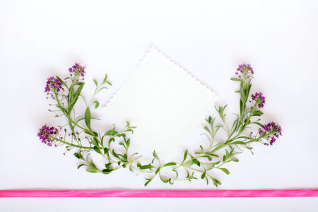 Installation of leaves and flowers decorated with a pink ribbon top view / background for congratulationsの写真素材