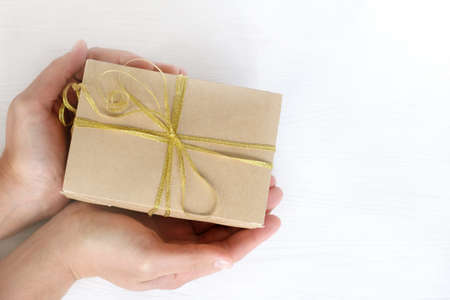 festive gift in hands, top view / presenting a surprise in boxの写真素材