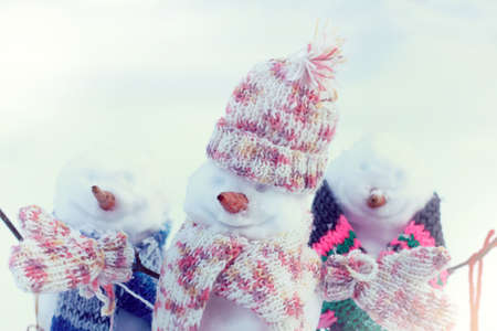 funny snowmen in warm scarves in winter/ holiday festivities on vacationの写真素材