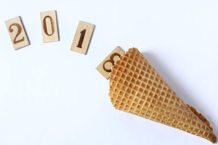 wooden numbers drop out their waffle horn on a light surface top view / wish abundance 2018