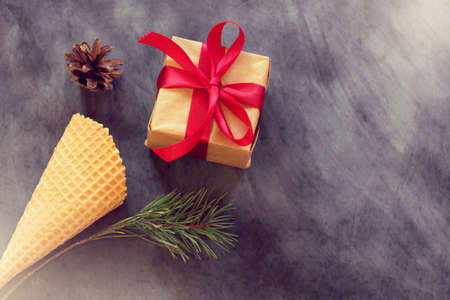 wafer cone, gift, pine branch and pine cone on a dark background top view of the coating / unexpected greetingsの写真素材