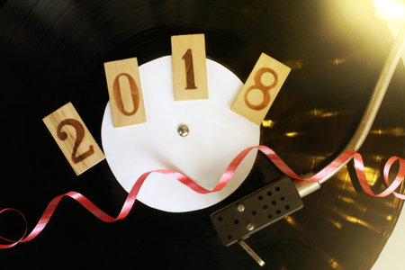 red ribbon serpentine on the background of an old vinyl plate in the player, top view / holiday...