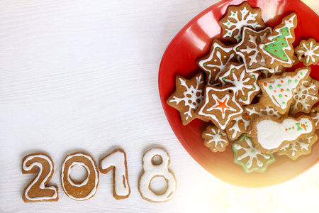 gingerbread figured cookies of different shapes in red plate and on the table top view / Christmas...