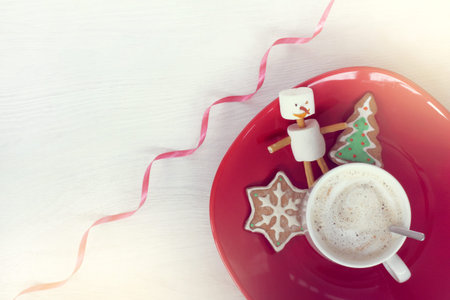 Cup of cappuccino, zephyr man and ginger Christmas tree in red plate top view / cheerful mood for...