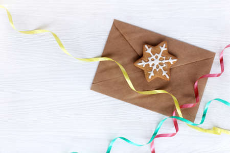 kraft envelope with ginger Christmas snowflake and color serpentine top view / congratulatory holiday letterの写真素材