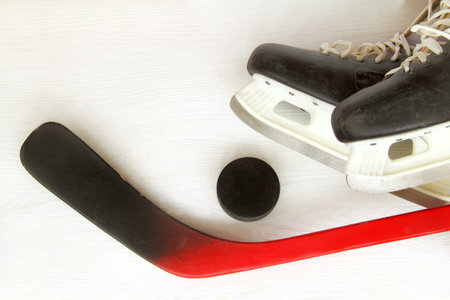 flat layout of old skates, hockey puck and putter on a light surface top view / sports equipment for...