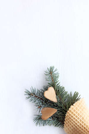 two hearts of cookies with branch of an evergreen tree in waffle horn / romantic to share feelingsの写真素材