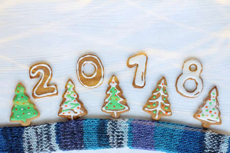 Five festively decorated Christmas trees in the form of cookies and edible number on blue scarf / delicious winter warming atmosphereの写真素材