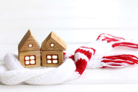 Two wooden houses stand side by side wrapped in a white-red scarf / warm relations between neighborsの写真素材