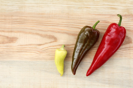 three different fruits of pepper on a wooden table top view / for every taste