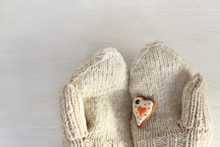 biscuits in the shape of heart cookies on the background of mittens / edible holiday gift