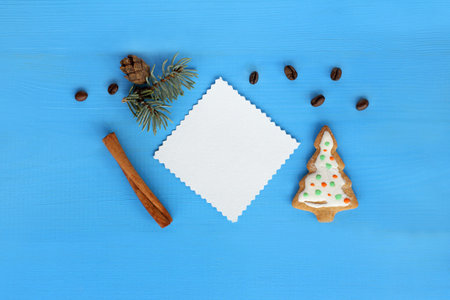 white blank, fir-tree, cinnamon and coffee beans on a blue background / atmosphere of winter...