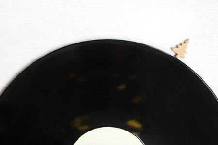small tree and an old vinyl record on a light surface top view / winter melodies in retro style