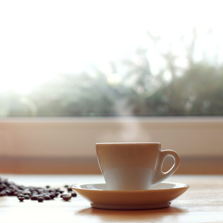 white coffee cup on the table by the window / warming hot drink