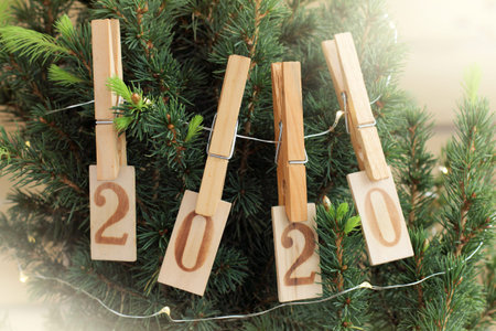 holiday tree is decorated with a garland and wooden figures with attached clothespins. anniversary...