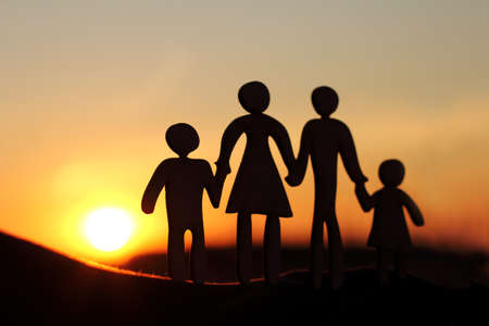 Unrecognizable silhouette of a family who admires the sunset together. concept of walking parents with childrenの写真素材