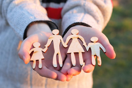 wooden silhouette of parents with children in their hands. family careの写真素材