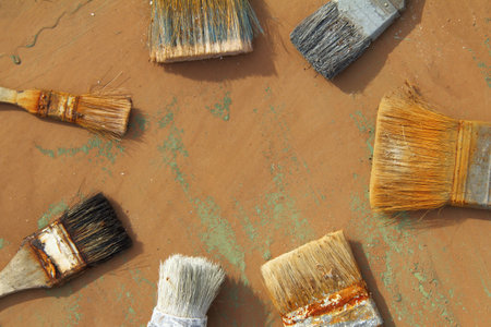 Old brushes used many times laid out in a circle on the table in the studio top view. tools for...