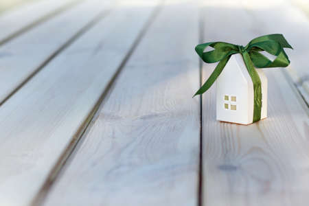 Paper house layout wrapped with gift ribbon against the background of building materials. housing readiness conceptの写真素材