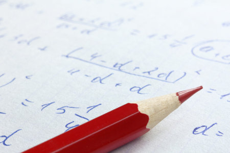 sharpened red pencil on the background of mathematical formulas in notebook close up. checking and...