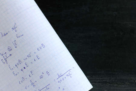 copybook abstract with formulas on black chalkboard background. solving problems in physicsの写真素材