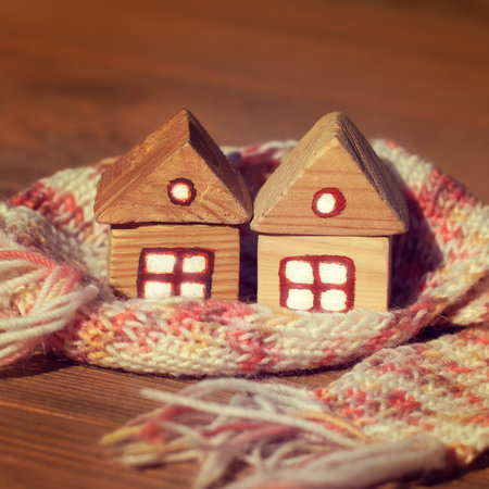 two houses wrapped in pink and white scarf together. joint insulation real estate heatingの写真素材