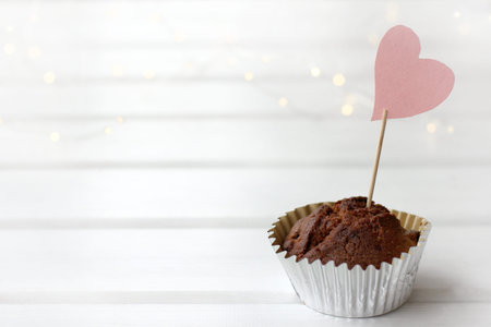 chocolate muffin with a heart-shaped sign on the table. favorite sweet diet