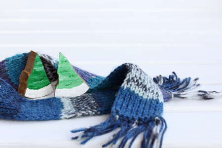 two wooden christmas trees wrapped in a scarf. together warmer on a cold dayの写真素材