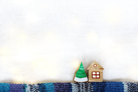 wooden house and Christmas tree on the background of festive lights. fabulous winter landscape