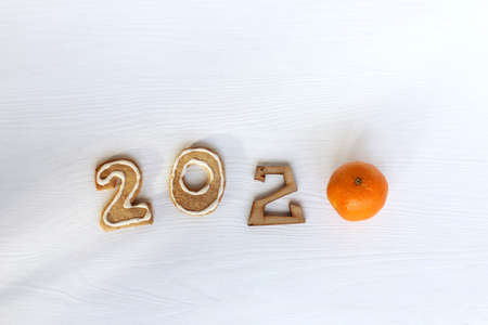 gingerbread cookie and mandarin orange showing year 2020 on the table top view.の写真素材