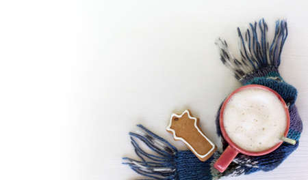 mug with frothy cappuccino and gingerbread cookie with a scarf on the table top view. fireworks festive tasteの写真素材