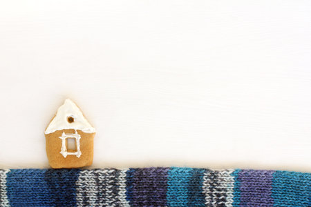 a gingerbread house with icing and a knitted blue scarf. delicious winter landscapeの写真素材