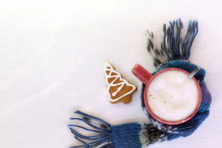 mug with foamy cappuccino and ginger Christmas tree, scarf and on a table top view. coffee break of winter weekendの写真素材