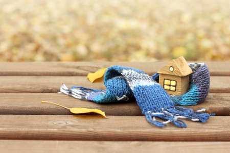 mock up of a wooden house in a warm scarf in the autumn. comfortable living in self-isolationの写真素材
